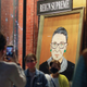 Children are photographed in front of a painting in a storefront on Broadway of Associate Justice of the Supreme Court of the United States Ruth Bader Ginsburg who passed away in Manhattan, New York City